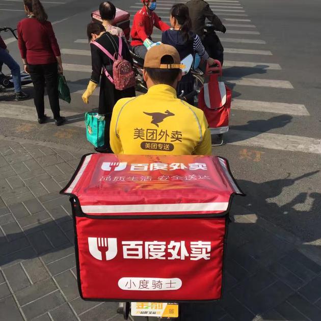 载着百度外卖箱子的美团外卖骑手。不同平台的骑手见面会互相问好，是交流公司的薪金变动情况，伺机而动，路上遇到困难也会相互帮衬。图片来源：网络